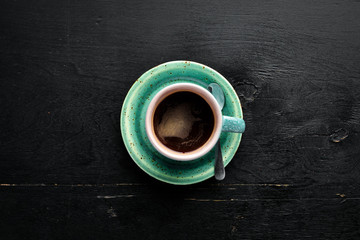A cup of black coffee on a wooden background. Free space for your text. Top view.
