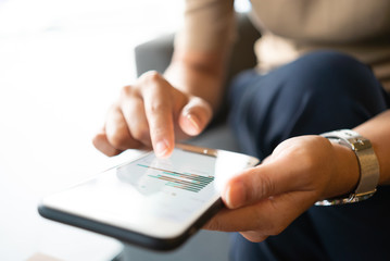 Asian woman looking at some charts on her mobile phone while sitting at coffee shop