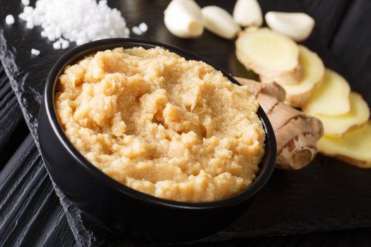 Fresh Ginger and Garlic paste or Adrak Lahsun puree in a ceramic bowl. horizontal