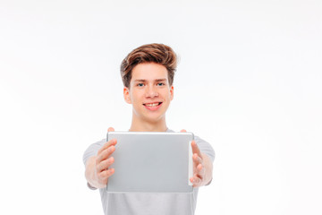 Fototapeta premium Attractive young man holding tablet in hands and smiling on whit