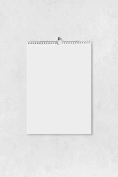 Blank vertical paper sheet of notebook hanging on abstract wall
