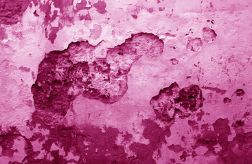 Сraked weathered cement wall texture in pink tone.