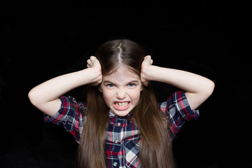 Fototapeta premium portrait of angry girl on black background, problems with parents concept