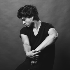 Portrait of Handsome Young Man. A Men Posing on a Gray Background. Black And White Photo