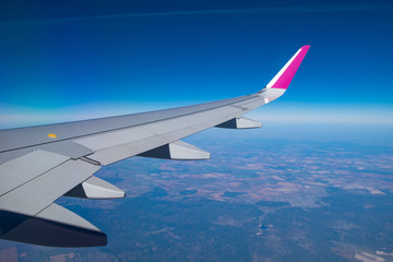 Fototapeta premium View to Airplane wing out of porthole window