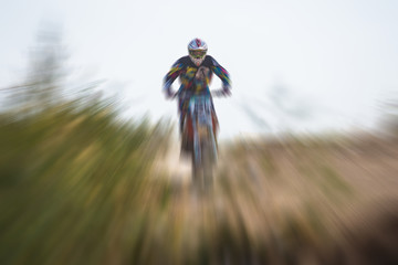 Blurry image of motorcycle riders during motocross race with zoom effect