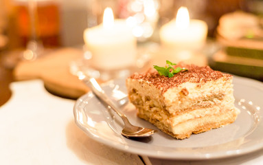 tiramisu by candlelight, romantic date in Italy, tiramisu dessert on a porcelain plate