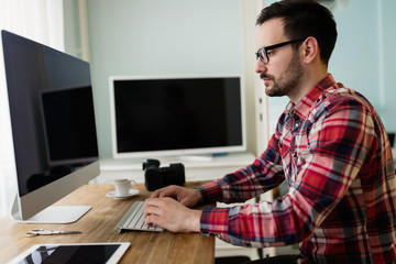 Young handsome designer working on project on computer
