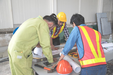 engineer people working and discussing with architecture or blueprint at construction site