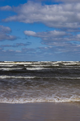 Landscape background with light clouds over Baltic sea near shoreline, selective focus