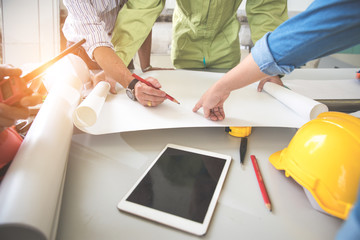 engineer people working and discussing with architecture or blueprint at construction site