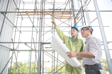 engineer people working and discussing with architecture or blueprint at construction site