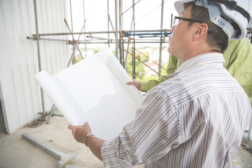engineer people working and discussing with architecture or blueprint at construction site