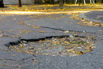 large pit with stones on the asphalt road