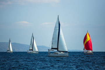 Fototapeta na wymiar Sailing luxury boats participate in yacht regatta in the Aegean Sea in Greece.