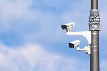 Security cameras on a pole in front of a cloudy sky. Security systems Prevention of offenses and...