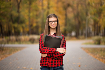 College student girl outdoors portrait. Smiling student girl