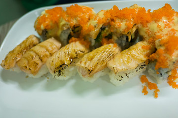 Grilled salmon sushi and tobiko sushi set  in white plate.