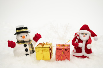 Snowman with gift box is standing in snowfall, Merry Christmas and happy New Year concept