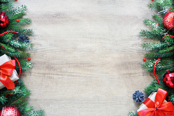 Christmas frame made of fir branches, red and golden decorations, gift boxes and pine cones on white wooden table. Christmas background. Flat lay. top view with copy space