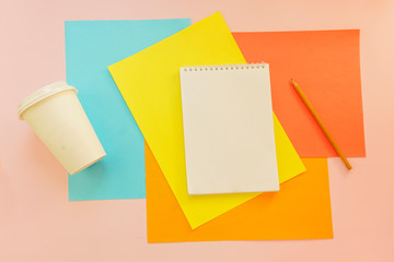 Top view flat lay picture with blank notepad page and different accessories on colored surface
