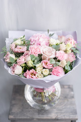 Beautiful spring bouquet in glass vase. Arrangement with various flowers. The concept of a flower shop. A set of photos for a site or catalogue. Work florist.