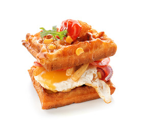 Delicious waffles with fried egg on white background