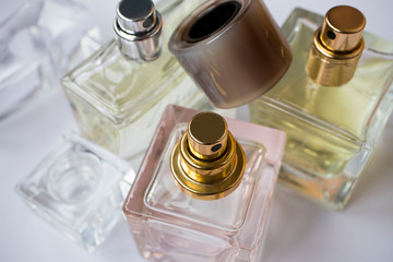 open bottles with women's perfume on white background