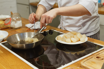 Hand of man take cooking fry scallops in a pan with butter close up