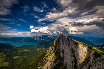 Panoramic view of mountains from Schafberg peak in Salzkammergut, Austria in a beautiful summer day with dramatic clouds and Attersee in the background