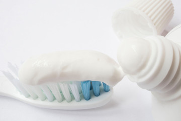 Fototapeta na wymiar Squeezing toothpaste onto toothbrush on white background