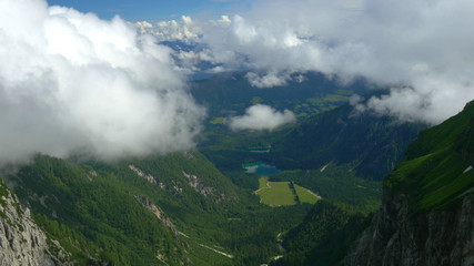 AERIAL: Flying above the forest covered mountains and towards two small lakes.