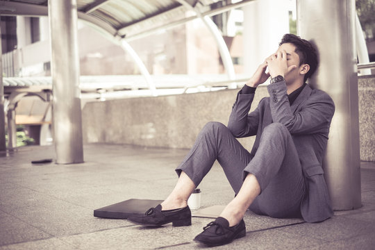 Despair sad businessman sit on floor walk way after business project fail and he lost oportunity from his work.
