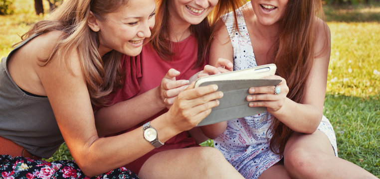 summer shopping online, people using social media, group of girls friends looking at tablet computer and smiling - Powered by Adobe