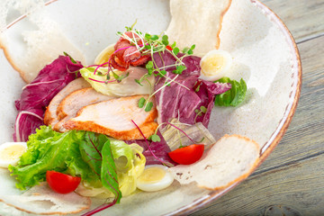 Fresh salad with chicken breast, arugula and tomato. Top view