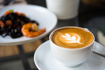 Latte coffee or coffe on the table of cafe in the morning  