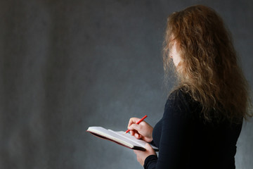 girl with a book in her hands on a dark background.
