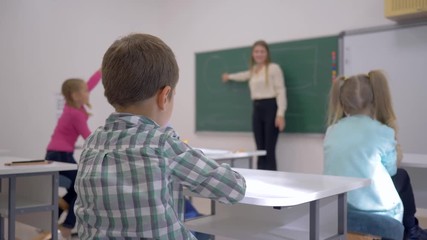 children education, schoolkids at lesson listen to teacher at blackboard in focused in classroom of Junior School