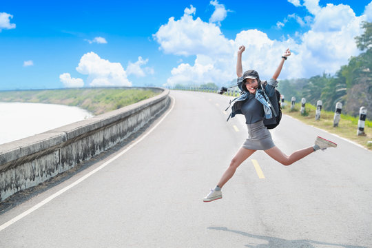 portrait of cheerful and beautiful woman jumping while traveling on holiday vacation