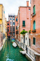 Fototapeta na wymiar Colorful water canal street with parked boats in Venice Italy