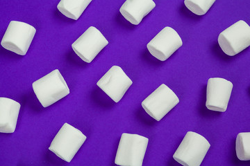 marshmallow laid out on violet paper background.