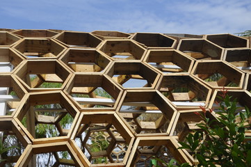 Shading walkway made of wood in the shape of a hexagon at Floria Garden in Putrajaya, Malaysia. The...