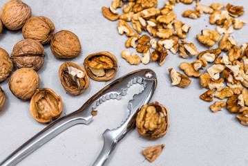 Whole walnuts, nutcracker and cracked nuts
