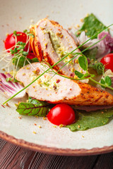 Fresh salad with chicken breast, arugula and tomato on a plate