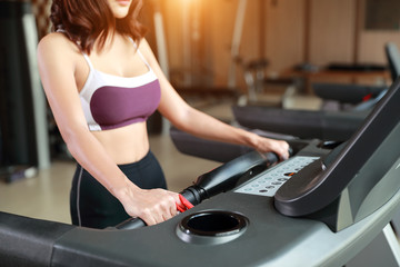 Fototapeta na wymiar portrait of young healthy and sporty woman using exercise machine in gym (this image for fitness and workout concept)
