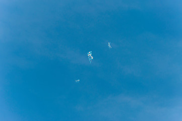 Fototapeta na wymiar Far away in the sky bunches of flying balloons