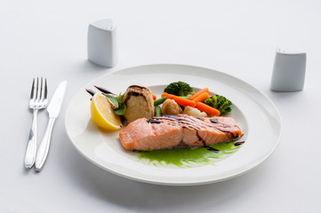 Salmon with sauce, rice, vegetables mushrooms and lemon