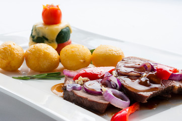 Decorated food. Beef with onion sauce, potatoes and vegetables.