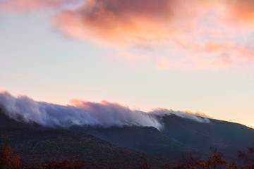 Naklejka na ściany i meble Peaks of green mountains in pink clouds at sunset. White Mountain National Park. USA. New Hamshire. 