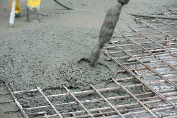 The wet concrete is poured on a steel reinforcement bar to form strong floor slabs called Reinforce...